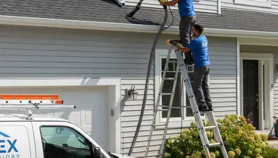 Technician providing professional gutter cleaning service on vinyl siding home in Nashville, TN